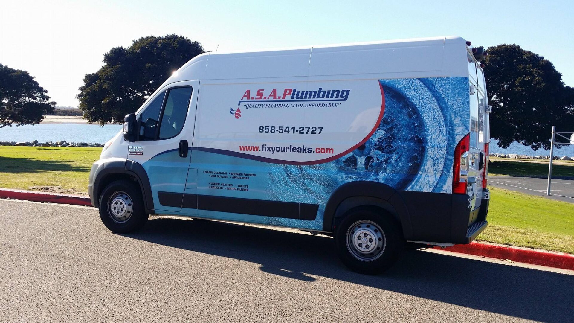 A white van with blue and red lettering on the side.